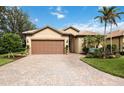 Attractive home with paver driveway, landscaping, and a two-car garage at 13912 Rinuccio St, Venice, FL 34293