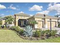Beautiful single-Gathering home featuring a three-car garage, manicured landscaping, and a tile roof at 169 N Cayman Isles Blvd, Englewood, FL 34223