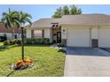 Single story home with a two car garage and palm trees at 406 Pendleton Dr, Venice, FL 34292