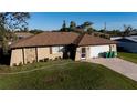 Single story house with a brown roof, white garage door, and a landscaped yard at 4222 Cockrell St, Port Charlotte, FL 33948