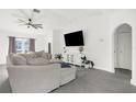 Bright living room with gray sectional sofa, large TV, and tile floors at 4467 Cinderella Cir, North Port, FL 34286
