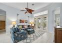 Inviting living room featuring a decorative ceiling fan, neutral paint, and french doors leading to the lanai at 5019 Bella Terra Dr, Venice, FL 34293