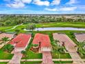 Community view showcasing houses with red tile roofs near a golf course at 5633 Whispering Oaks Dr, North Port, FL 34287