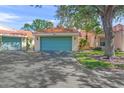 Villa with a two-car garage door painted light blue and a Spanish tile roof at 606 Marcus St # 26, Venice, FL 34285