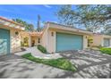 Condo with teal garage door and a landscaped front yard at 606 Marcus St # 26, Venice, FL 34285