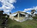 Side view of yellow single wide mobile home with landscaping at 782 Londra Dr, Venice, FL 34285