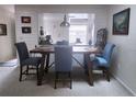 Bright dining room with a wooden table and four blue chairs, overlooking the kitchen at 145 Jose Gaspar Dr # 145, Englewood, FL 34223