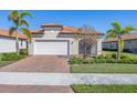 Single-Gathering home exterior featuring a white garage door and landscaping at 24176 Spartina Dr, Venice, FL 34293
