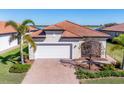 Single-Gathering home exterior with white garage door and brick driveway at 24176 Spartina Dr, Venice, FL 34293