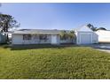 Single-story home with gray siding, attached garage, and spacious lawn at 3181 Nekoosa St, North Port, FL 34287