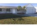 Gray house with a two-car garage and well-maintained lawn at 3181 Nekoosa St, North Port, FL 34287
