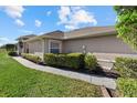 Back view of a villa with a walkway, neat hedges, and a glimpse of the backyard at 3897 Fairway Dr, North Port, FL 34287