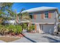 Two-story house with gray siding, orange shutters, and a paved driveway at 6405 Gulf Dr, Holmes Beach, FL 34217