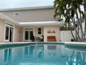 Relaxing backyard pool with a sitting area, palms, and white privacy fence at 6405 Gulf Dr, Holmes Beach, FL 34217
