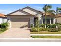 Charming one-story home with brick driveway, palm trees, and well-maintained lawn at 660 Ravello Blvd, Nokomis, FL 34275