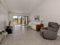 Bright living room with tile floors, and access to a patio at 694 Bird Bay W Dr # 137, Venice, FL 34285