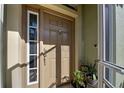 Front entry features a brown door and potted plants in a screened porch at 143 Fontanelle Cir, Venice, FL 34292