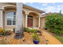 Front entry with red double doors and well-manicured landscaping at 150 Marker Rd, Rotonda West, FL 33947