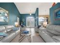 Living room with double entry doors and light gray couches at 150 Marker Rd, Rotonda West, FL 33947
