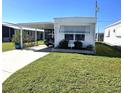 Landscaped yard with white mobile home and carport at 218 Trailorama Dr, North Port, FL 34287