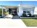 Front view of a white mobile home with carport at 218 Trailorama Dr, North Port, FL 34287