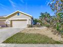 Tan house with a two-car garage and nicely landscaped front at 4334 Lenox Blvd, Venice, FL 34293