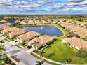 An aerial perspective of a peaceful neighborhood featuring a central lake at 4980 Whispering Oaks Dr, North Port, FL 34287