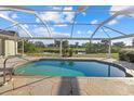 Inviting screened-in pool with a scenic view and stone patio at 52 Fairway Rd, Rotonda West, FL 33947