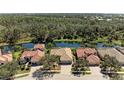 Beautiful aerial view of several homes backing onto a tranquil pond surrounded by lush greenery at 608 Crane Prairie Way, Osprey, FL 34229
