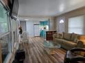 Open living area with teal kitchen, laminate floors, and comfy seating at 113 Ravenna N St, Nokomis, FL 34275