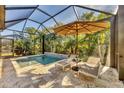 Private screened-in pool with lounge chairs and lush landscaping at 11897 Hunters Creek Rd, Venice, FL 34293