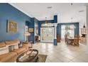 Spacious living room with light tile floors, brown leather couch, and formal dining area at 125 Areca Palm Ct, Venice, FL 34292