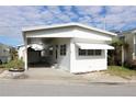 White single-wide mobile home with carport and small yard at 149 S Port Dr, Venice, FL 34285