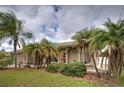 House with palm trees and lush landscaping in the front yard at 23102 Madelyn Ave, Port Charlotte, FL 33954
