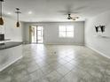 Bright living room featuring tile flooring, a ceiling fan, and sliding glass doors to the outdoor living space at 2501 Sherman Oak Dr, North Port, FL 34289