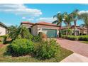 Single-story home with a light green garage door and brick driveway at 2572 Daisy Dr, North Port, FL 34289