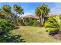 Exterior view of house amidst tropical foliage and lawn at 3200 Rowland Dr, Punta Gorda, FL 33980
