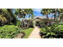 Front walkway of single-story home surrounded by tropical foliage at 3200 Rowland Dr, Punta Gorda, FL 33980