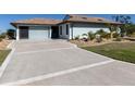 Large concrete driveway with decorative lines leading to the garage at 4301 Oak Terrace Cir, Port Charlotte, FL 33953