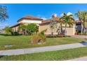 Exterior view of a home with a clay tile roof, landscaped front yard, and a welcoming driveway at 5584 Cantucci St, Nokomis, FL 34275