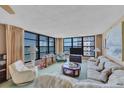 Spacious living room with ocean views, comfortable seating, and large windows at 629 Alhambra Rd # 704, Venice, FL 34285