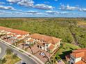 Stunning aerial view of townhomes with tile roofs, brick driveways and lush surroundings at 10039 Crooked Creek Dr # 203, Venice, FL 34293