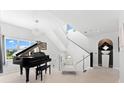 Elegant foyer with a grand piano, modern staircase, and stylish decor at 130 Green Dolphin Dr, Placida, FL 33946