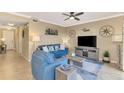 Comfortable living room features a blue sofa, ceiling fan, and coastal-themed decorations at 17118 Vardon Ter # 202, Bradenton, FL 34211