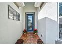 Front entry with a blue door, red flowers, and terracotta tile at 19279 Jacinda St, Venice, FL 34293