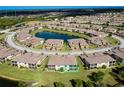 An aerial view showcasing the community layout with a focus on the location of the property, including surrounding homes and amenities like a pond at 20100 Ragazza Cir # 101, Venice, FL 34293