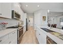 Modern kitchen featuring white cabinetry, stainless steel appliances, and sleek countertops at 26069 Norman Dr, Englewood, FL 34223