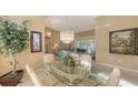 Spacious dining area with glass-top table, wicker chairs, and view into living room at 275 Royal Oak Way, Venice, FL 34292