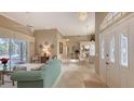 Open living room with teal sofa, and view into dining area at 275 Royal Oak Way, Venice, FL 34292