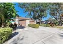 Two-car garage and a paved driveway, surrounded by greenery at 4417 Park Lake N Ter, Bradenton, FL 34209